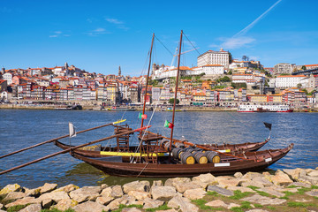 Fototapeta na wymiar Boat with barrels of porto wine at river bank. Porto, Portugal