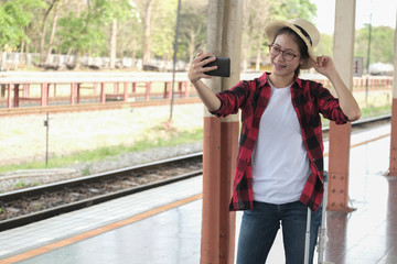 woman use smart phone to take selfie photo at train station. traveler  travel together on holiday