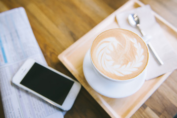 cup of coffee tablet and smart phone on wooden table