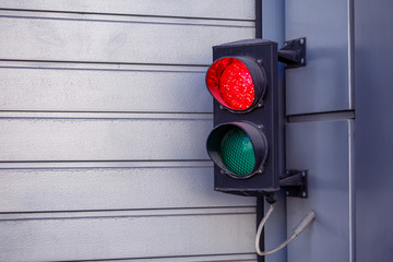 Two-color small traffic light. Red and green colors. Red light is on it
