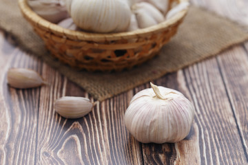 head of garlic and a wicker basket of garlic as a natural background