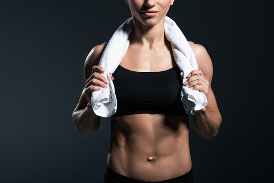cropped view of muscular sportswoman with towel after training, isolated on grey