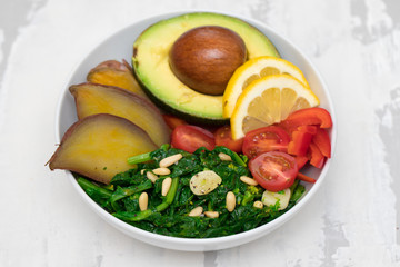 vegetables with lemon in white bowl on ceramic dish