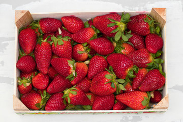 strawberries in wooden box on ceramic dish
