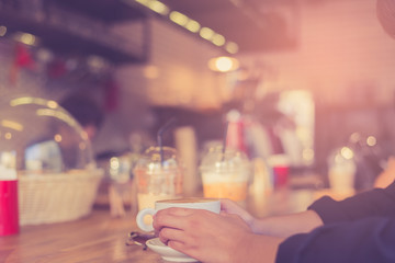 Female hands holding cup of coffee.