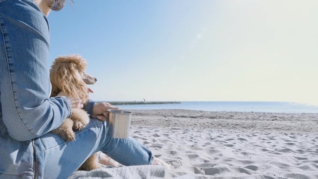 Woman with her dog at sandy sea beach . Conceptual freedom, travel and holidays image .