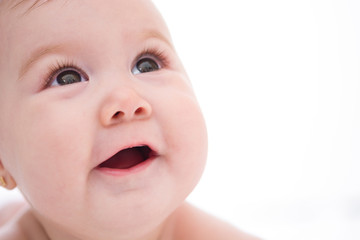 Adorable little baby girl smiling on white background. Close up

