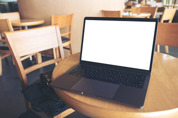 Mockup image of computer laptop with blank white desktop screen on wooden table in cafe