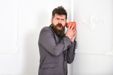 Hipster in classic suit on outraged face secretly listen conversation. Man in white interior...