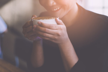 Female hands holding cup of coffee.