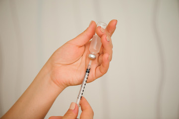 A girl fills a syringe for insulin injections. Diabetes. The short-acting insulin. Insulin injection at home.