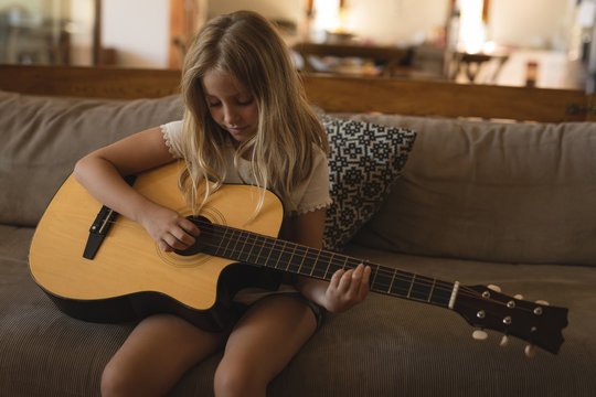 Girl playing guitar at home
