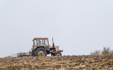 Tractor prepares a field for sowing