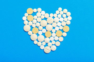 Pills are scattered over a blue background