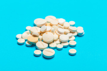 Pills are scattered over a blue background
