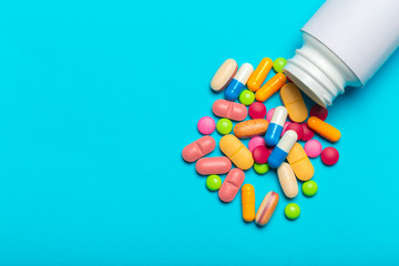 Pills are scattered over a blue background