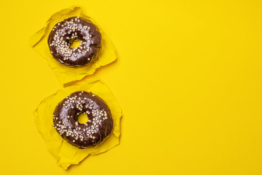 chocolate donut on a yellow background, top view