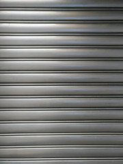 Obraz premium pattern of roll-up door in horizontal lines, shiny metallic material, with glowing part and shady part