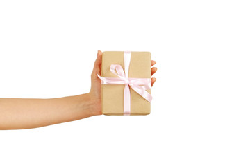 Close up of female hands holding birthday gift in vintage craft paper wrapping. Femenine composition with present in woman's arms.