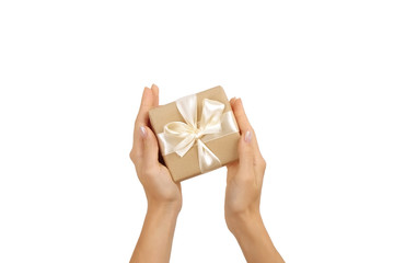 Close up of female hands holding birthday gift in vintage craft paper wrapping. Femenine composition with present in woman's arms.