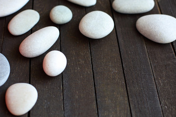 Fototapeta na wymiar white stones on dark wooden background