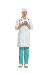 Beautiful young woman in white coat posing at studio. Full length studio shot isolated on white.