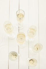 top view of champagne glasses on white wooden table