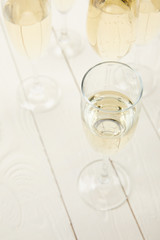 high angle view of champagne glasses on white wooden table