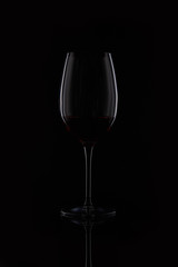 closeup shot of glass with red wine isolated on black background