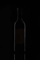 closeup view of bottle with red wine isolated on black background