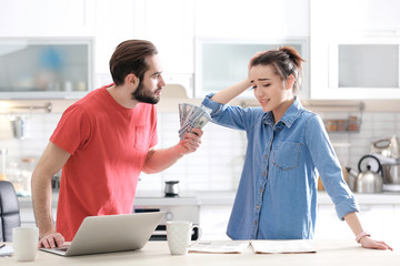 Young couple having argument about family budget in kitchen