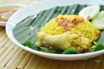 rice cooked with chicken in curry on plate with spicy sauce