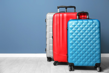 Different suitcases near color wall