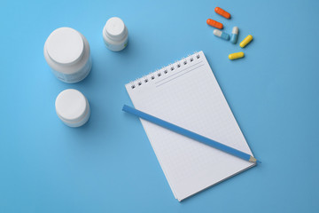 Pharmaceutical capsules, bottles and notepad with a pencil. Concept prescription, dosage, overdose, planning.