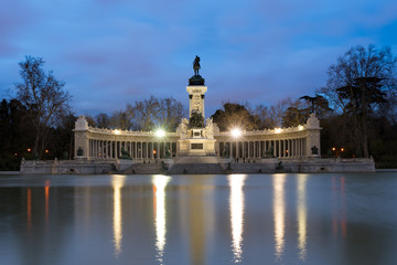 Fototapeta na wymiar Night cityscape with lights at the memorial in Retiro city park, Madrid, Spain.