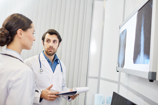 Image of two young doctors discussing x-ray results at the hospital