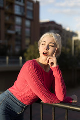 Portrait of a young blonde woman gesturing in the street