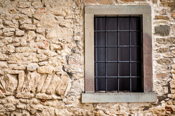 Window in stone wall. Barred window.