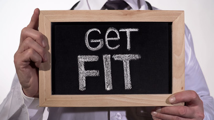 Get fit written on blackboard in doctor hands, active healthy life promotion