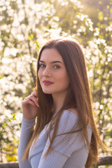 Young girl portrait with white bush in park