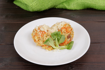 Risotto with carrot and cheese on table