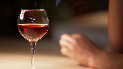 Beautiful glass of red wine standing on table at restaurant, evening time relax