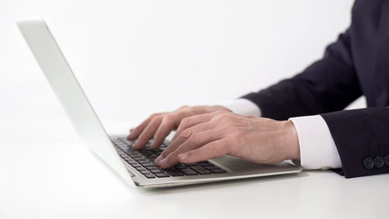 Hands of successful businessman typing on laptop, working on project report