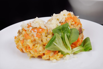 Risotto with carrot and cheese on black
