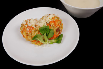 Risotto with carrot and cheese on black