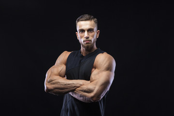 Fototapeta na wymiar Portrait of a muscular male model against black background