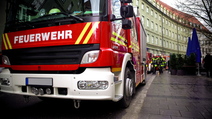 Firetruck in German, firefighters on background, fire and emergency services