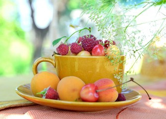 Cup of berries and bouquet of wildflowers