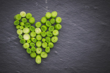 Overhead view of Slices of leek arranged on a table in a heart shape
