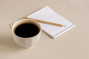Top view of the notebook, a Cup of coffee on a bright table.